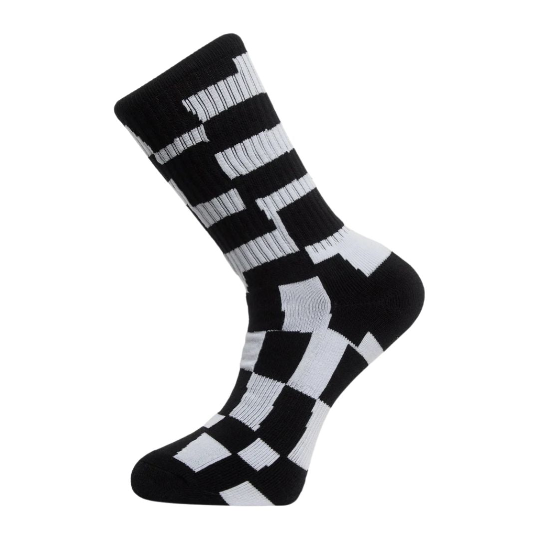 Calcetín Volcom Carrau Print Mixer Sock en estampado geométrico blanco y negro, vista de perfil mostrando el patrón de bloques irregulares tipo puzle.
