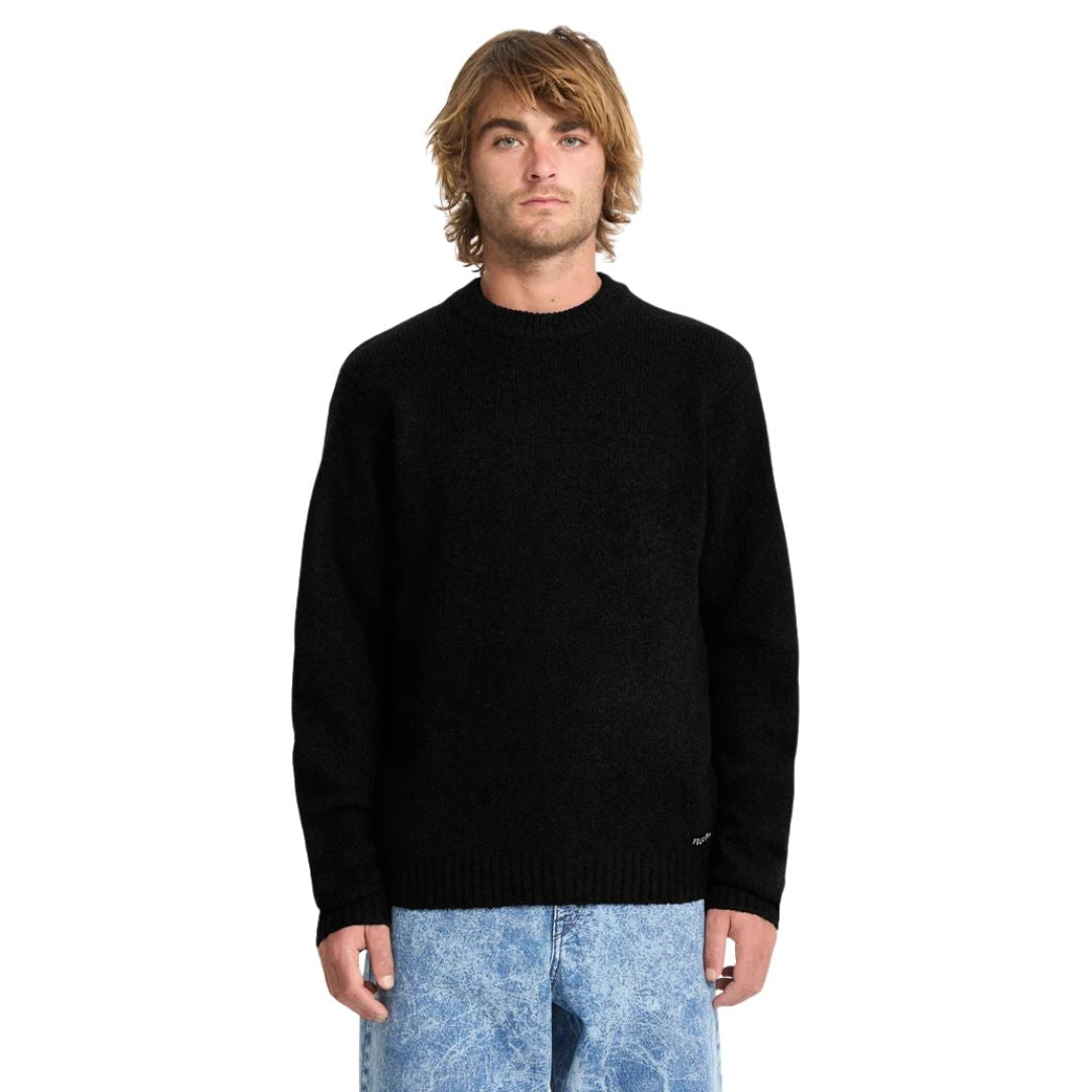 Hombre con jersey Volcom Edmonder II en color negro, vista frontal de medio cuerpo, mostrando el cuello redondo y la textura jaspeada del punto grueso.