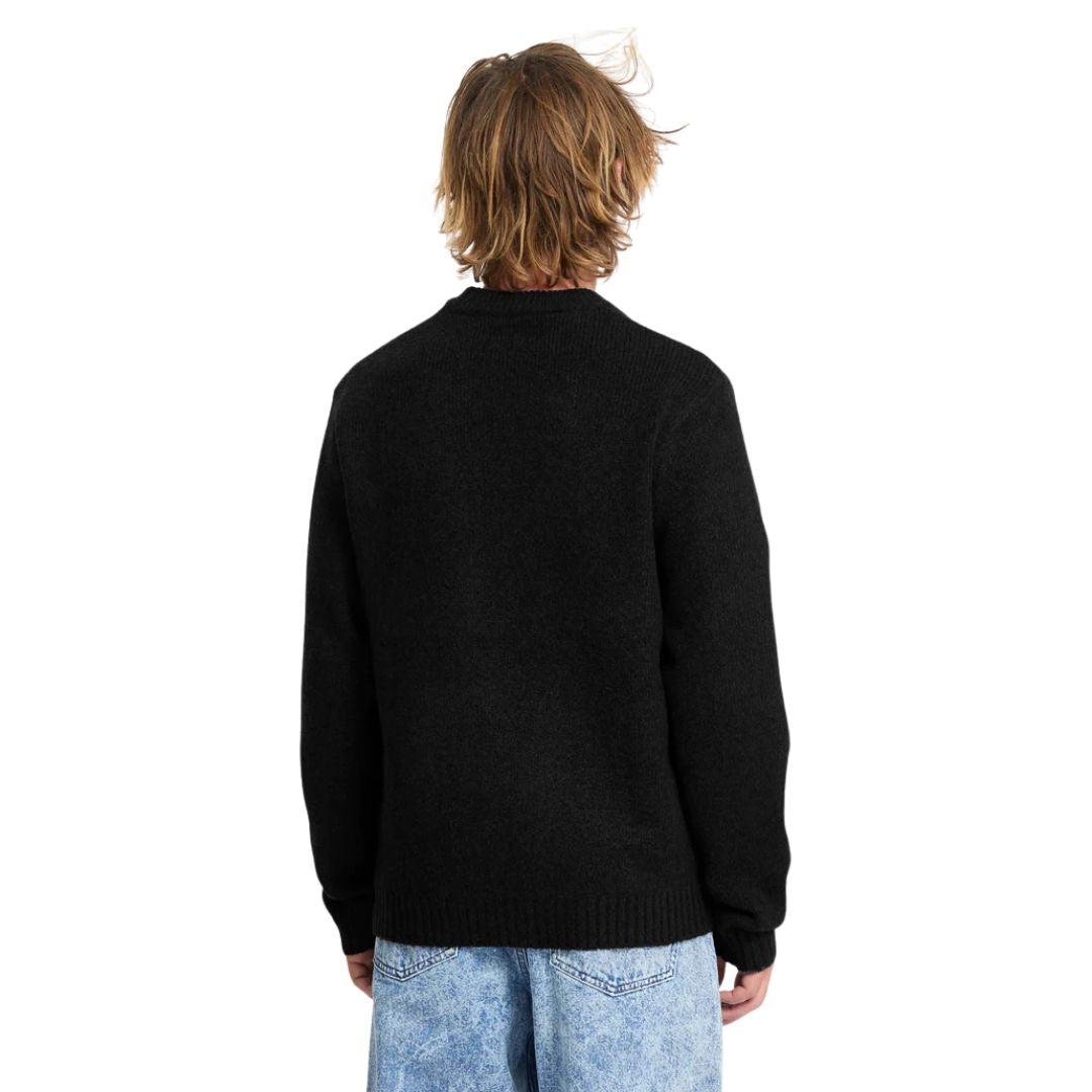 Vista trasera de hombre con jersey Volcom Edmonder II en color negro, mostrando el ajuste en la espalda y las mangas largas del tejido de punto grueso.