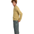 Vista lateral de hombre con jersey Volcom Edmonder II en color mostaza, mostrando la etiqueta Volcom cosida junto al bajo y el corte normal de la prenda.