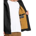 Chaqueta Volcom Hernan 10K negra, vista interior mostrando forro acolchado mostaza.