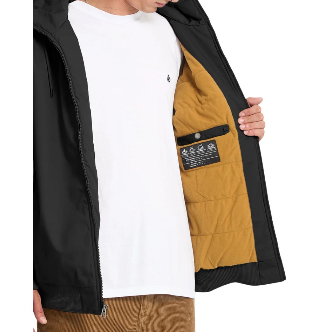 Chaqueta Volcom Hernan 10K negra, vista interior mostrando forro acolchado mostaza.