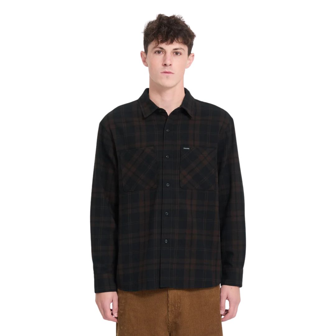 Hombre con camisa Volcom Hunkstone LS en color cacao a cuadros, vista frontal de medio cuerpo mostrando el doble bolsillo y el cuello simple de la camisa.