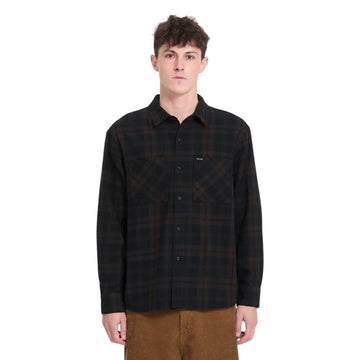 Hombre con camisa Volcom Hunkstone LS en color cacao a cuadros, vista frontal de medio cuerpo mostrando el doble bolsillo y el cuello simple de la camisa.