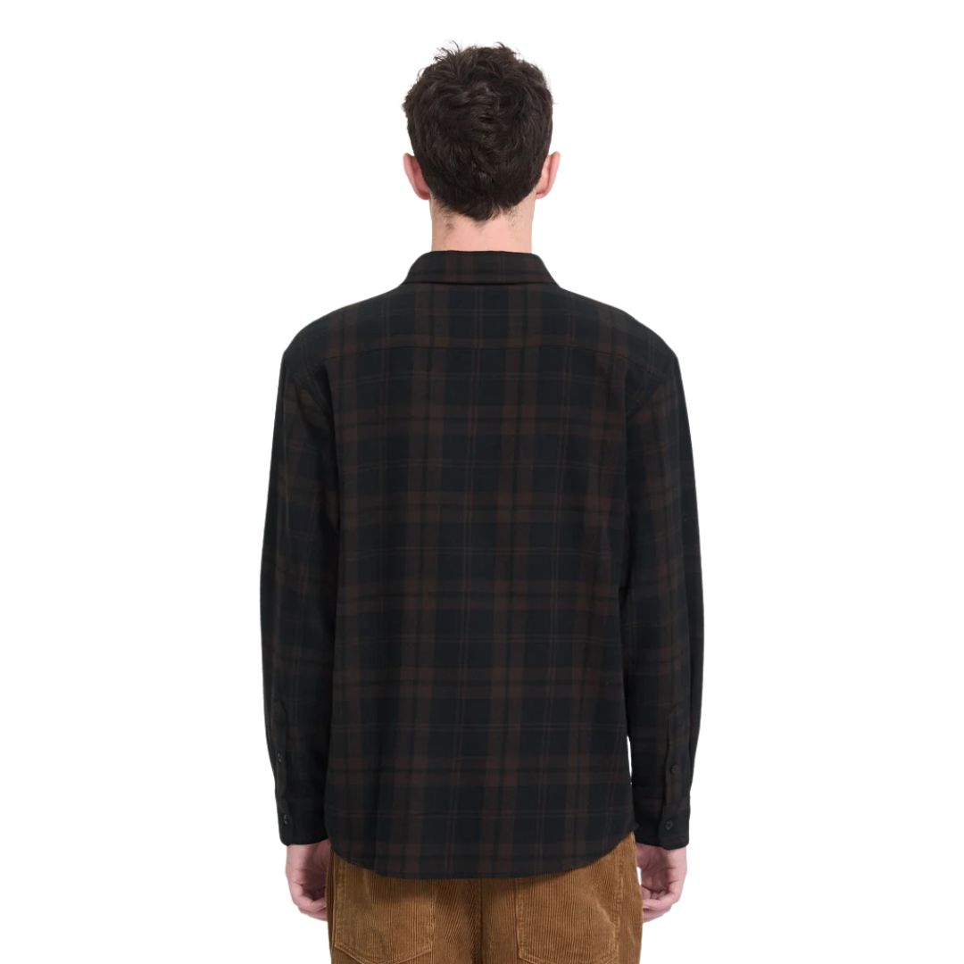 Vista trasera de hombre con camisa Volcom Hunkstone LS en color cacao a cuadros, mostrando el bordado Stone en la espalda y el corte boxy de la prenda.