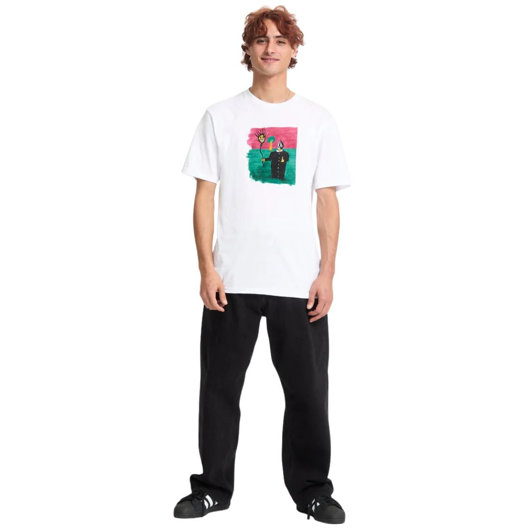 Modelo masculino vistiendo camiseta Volcom Issam BSC SST blanca con estampado multicolor, postura casual inclinada hacia adelante.