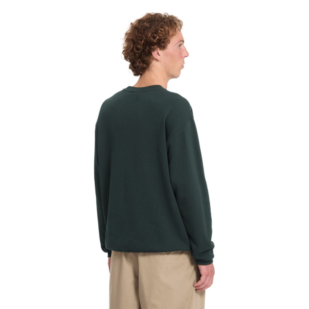 Sudadera Volcom Single Stone Crew en color Scarab, vista trasera sobre modelo, mostrando el corte clásico y la caída de las mangas largas hasta el puño.
