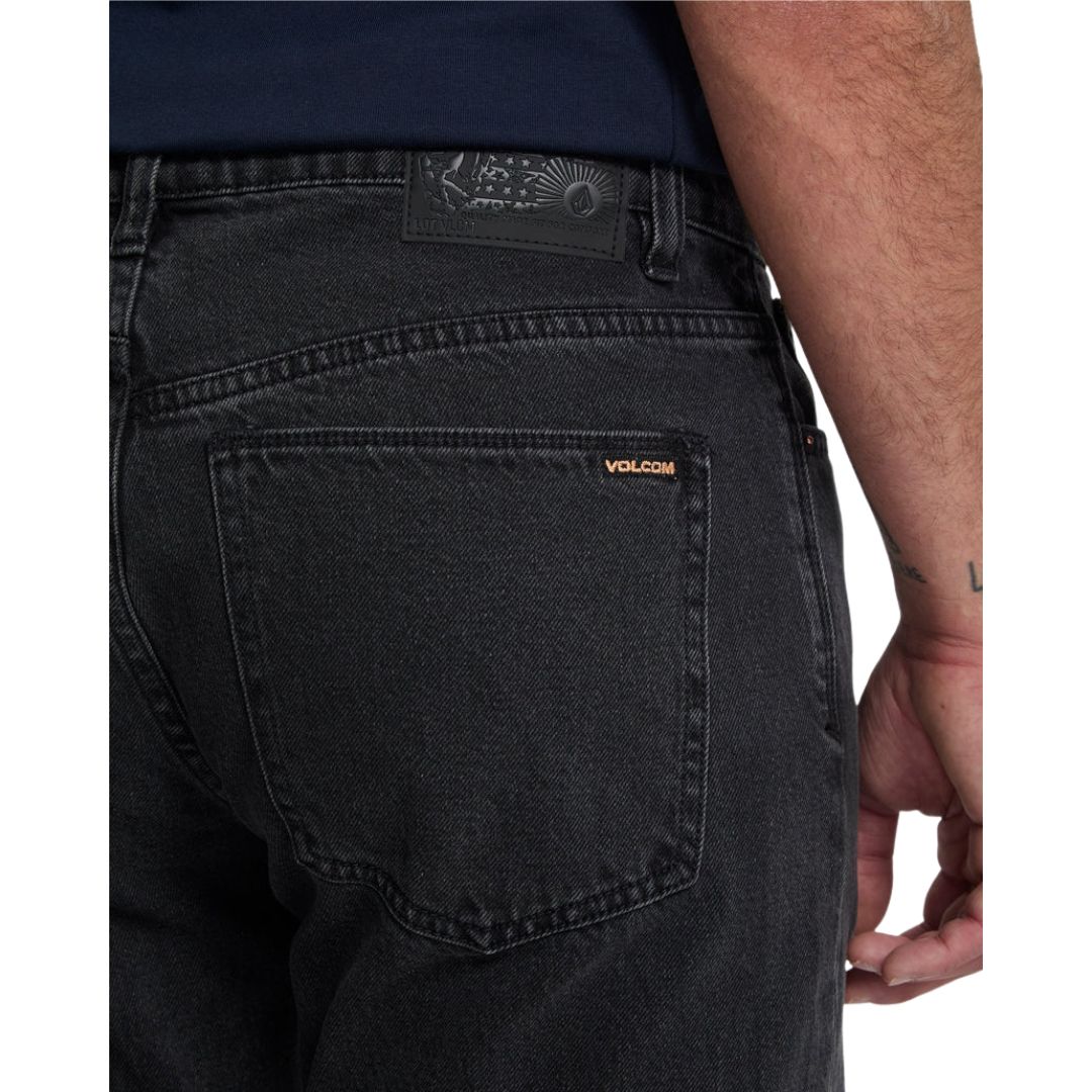 Detalle del bolsillo trasero del vaquero Volcom Kinkade Denim en negro lavado, con la etiqueta de cuero de la marca y la etiqueta tejida Volcom cosidas en el bolsillo.