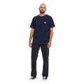 	Pantalón vaquero Volcom Kinkade Denim en negro lavado, vista frontal completa sobre modelo con camiseta azul marino, mostrando el corte normal y la pierna recta.