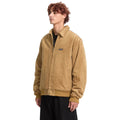 Hombre con chaqueta Volcom Kurtis en color armiño en ángulo de tres cuartos, luciendo el bolsillo lateral y el canalé en el bajo de la chaqueta completa.