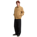 Hombre con chaqueta Volcom Kurtis en color armiño de cuerpo entero, con las manos en los bolsillos del pantalón, mostrando la textura de pana de la prenda.