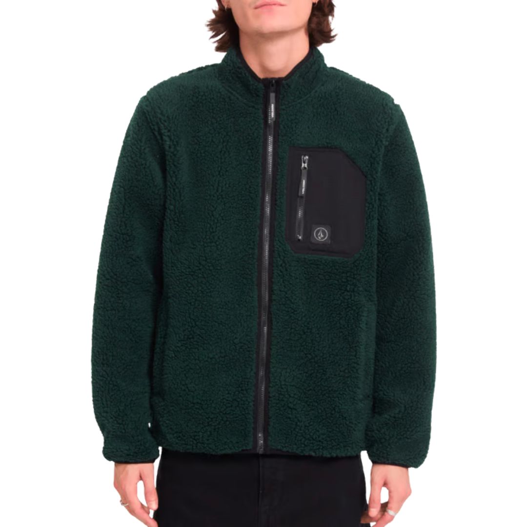 Detalle frontal de la sudadera Volcom Muzzer Fuzzar Zip en color verde escarabajo, con el bolsillo de pecho con cremallera y la etiqueta Volcom bien visibles.