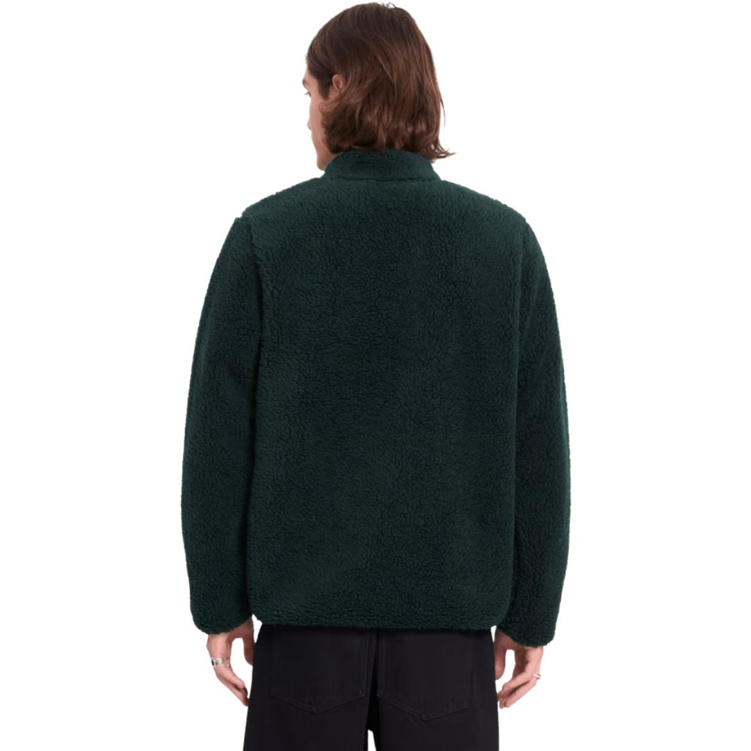 Vista trasera de hombre con sudadera Volcom Muzzer Fuzzar Zip en color verde escarabajo, mostrando el ajuste en la espalda y el corte amplio de la prenda.