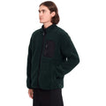 Hombre con sudadera Volcom Muzzer Fuzzar Zip en color verde escarabajo visto de perfil, luciendo el cuello alto con cremallera y el tejido de borreguillo.