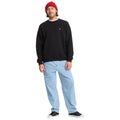 Sudadera Volcom Single Stone Crew negra, look frontal en modelo con gorro rojo y vaqueros