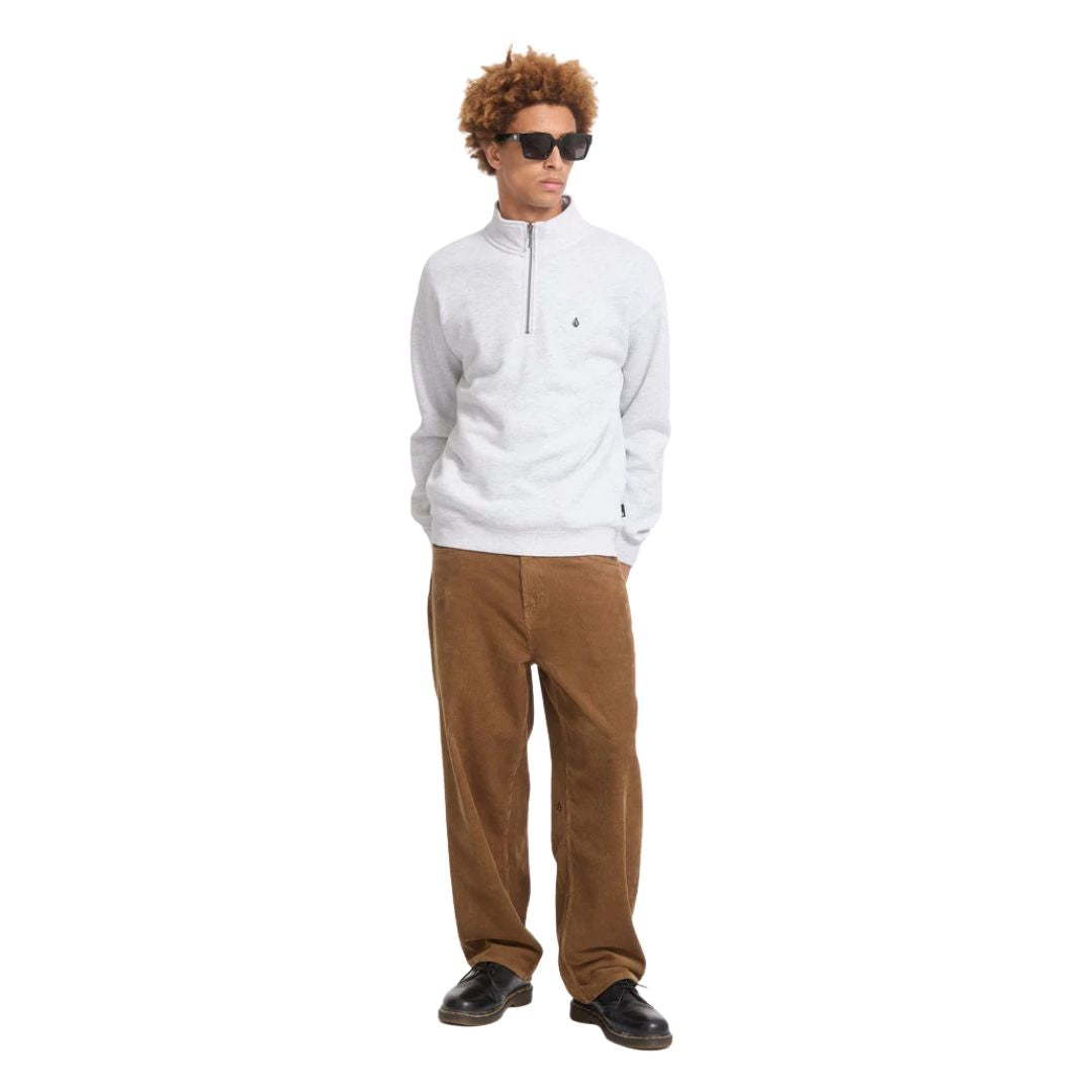 Modelo con el jersey Volcom Single Stone Quarter Zip en color gris hueso jaspeado de cuerpo entero, vista frontal con la mirada hacia un lado y gafas de sol.