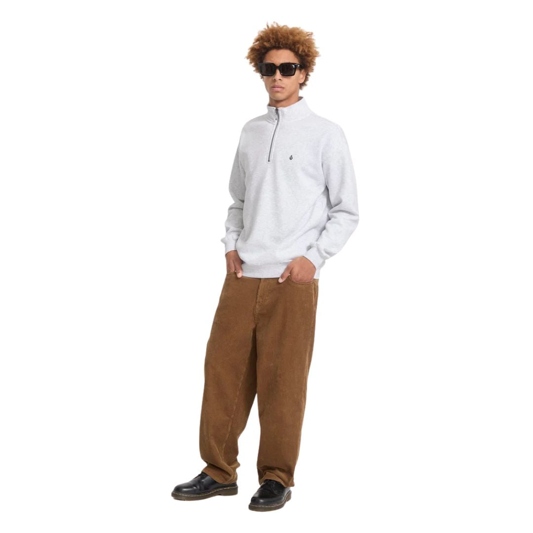 Modelo con el jersey Volcom Single Stone Quarter Zip en color gris hueso jaspeado de cuerpo entero, con gafas de sol y manos en los bolsillos del pantalón.