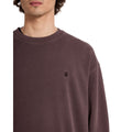 Detalle bordado Stone en sudadera Volcom marrón oscuro cuello redondo.