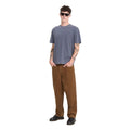 Camiseta Volcom Solid Stone EMB SST en color storm blue, vista de perfil de tres cuartos con gafas de sol, mostrando la caída de la manga y el bajo de la prenda.