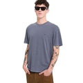 Modelo con la camiseta Volcom Solid Stone EMB SST en color storm blue, vista frontal sin gafas, con los brazos relajados a los lados mostrando el logo bordado en el pecho.