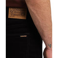 Detalle en primer plano del bolsillo trasero derecho del pantalón Volcom Solver 5 Pocket Cord en color negro, con la etiqueta de piel Volcom a la vista.
