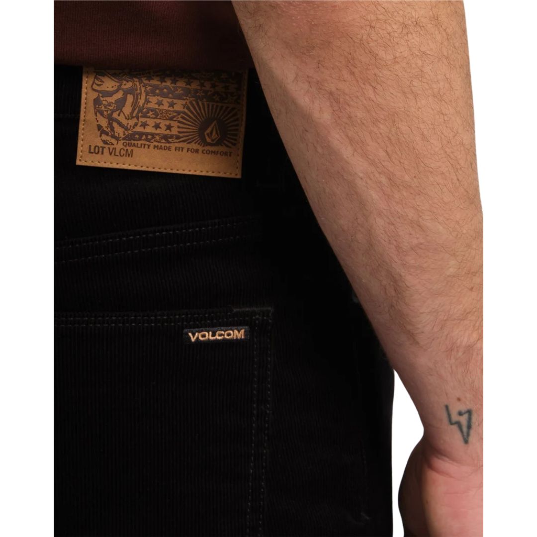 Detalle en primer plano del bolsillo trasero derecho del pantalón Volcom Solver 5 Pocket Cord en color negro, con la etiqueta de piel Volcom a la vista.