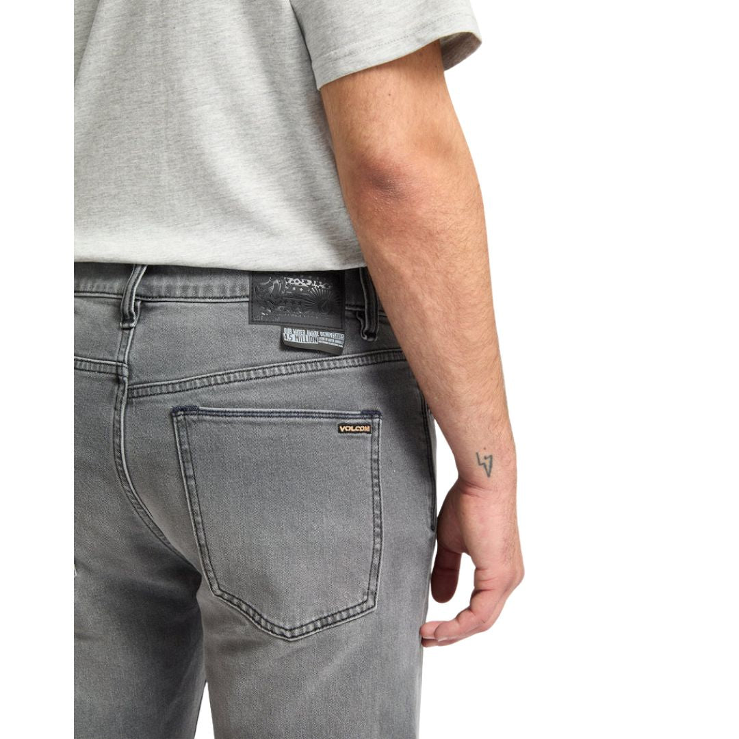 Detalle del bolsillo trasero de los vaqueros Volcom Solver Denim gris Concrete con etiqueta de marca Volcom.
