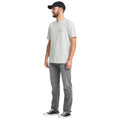 Vista tres cuartos de los vaqueros Volcom Solver Denim gris Concrete en modelo masculino con camiseta gris y gorra negra.