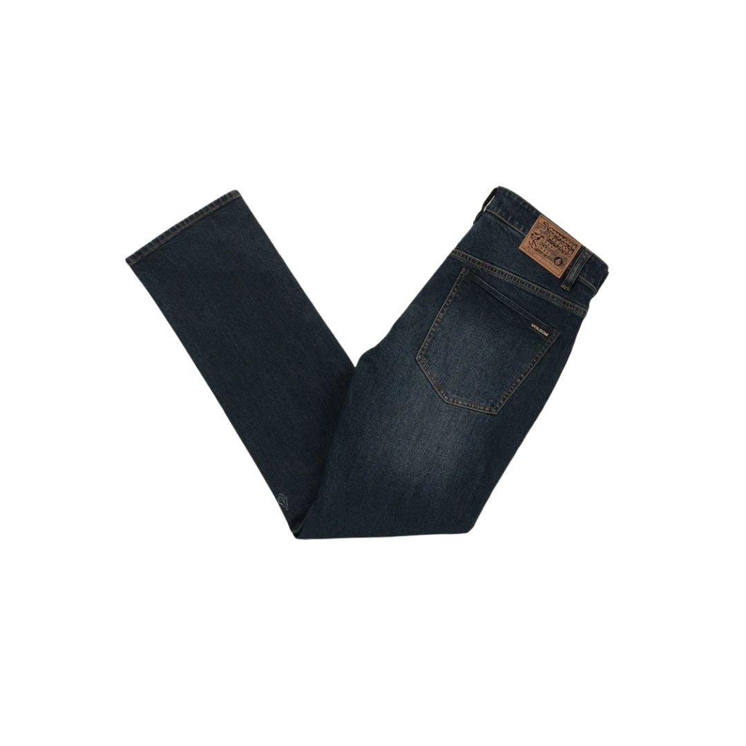 Vaqueros Volcom Solver Denim color New Washed Blue, doblados mostrando bolsillo trasero y etiqueta de piel.