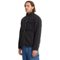 Modelo de pie con chaqueta Volcom Storm Stone Zip negro, vista lateral.