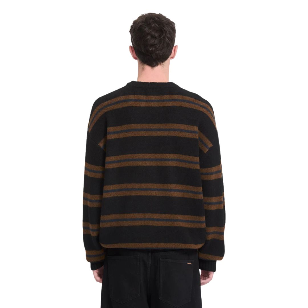 Vista trasera de hombre con jersey Volcom Striperstand en color negro de rayas, mostrando el ajuste en la espalda y el estampado jacquard completo del punto.