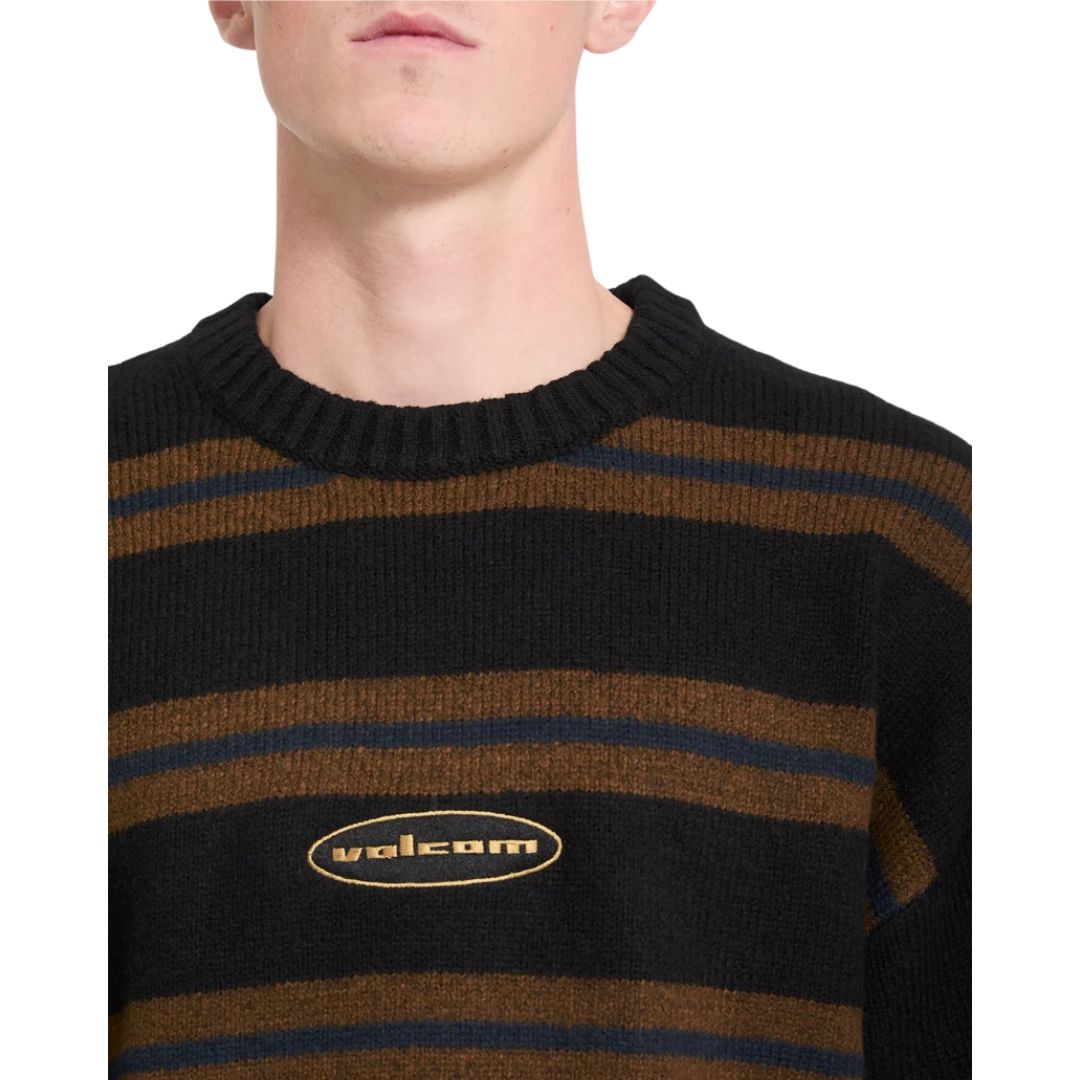 Detalle del cuello redondo y el logo Volcom bordado del jersey Striperstand en color negro de rayas, con vista cercana de la textura del punto jacquard.