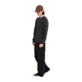 Modelo de cuerpo entero con el jersey Volcom Thermowhy Sweater negro, pantalón ancho y zapatillas, vista lateral en tres cuartos del jersey de punto gofrado