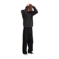 Modelo de cuerpo entero de espaldas con las manos en la cabeza y el jersey de punto gofrado Volcom Thermowhy Sweater negro, combinado con pantalón ancho