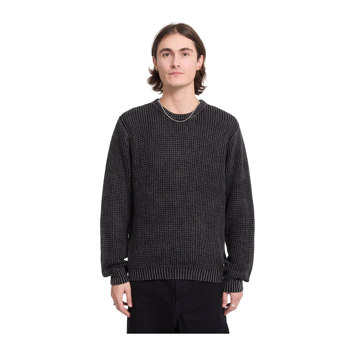 Vista frontal del jersey Volcom Thermowhy Sweater negro llevado por un modelo, con punto gofrado, cuello redondo y puños y bajo de canalé en toda la prenda