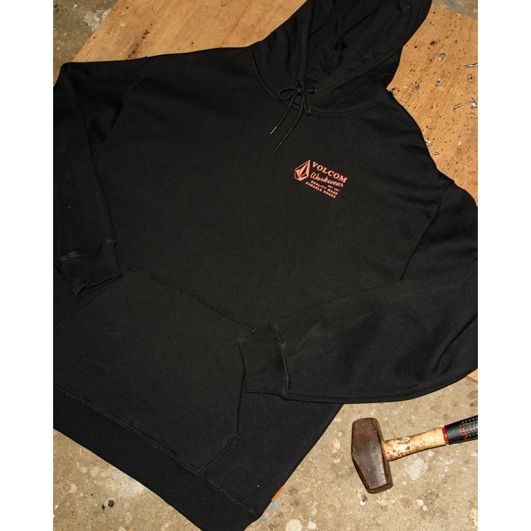Sudadera Volcom Workwear PO negra colocada en superficie con detalles del logotipo naranja en el pecho.