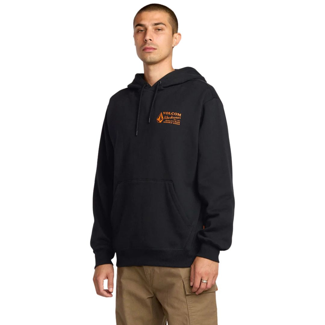 Modelo de frente con sudadera Volcom Workwear PO negra, capucha ajustada y bolsillo delantero.