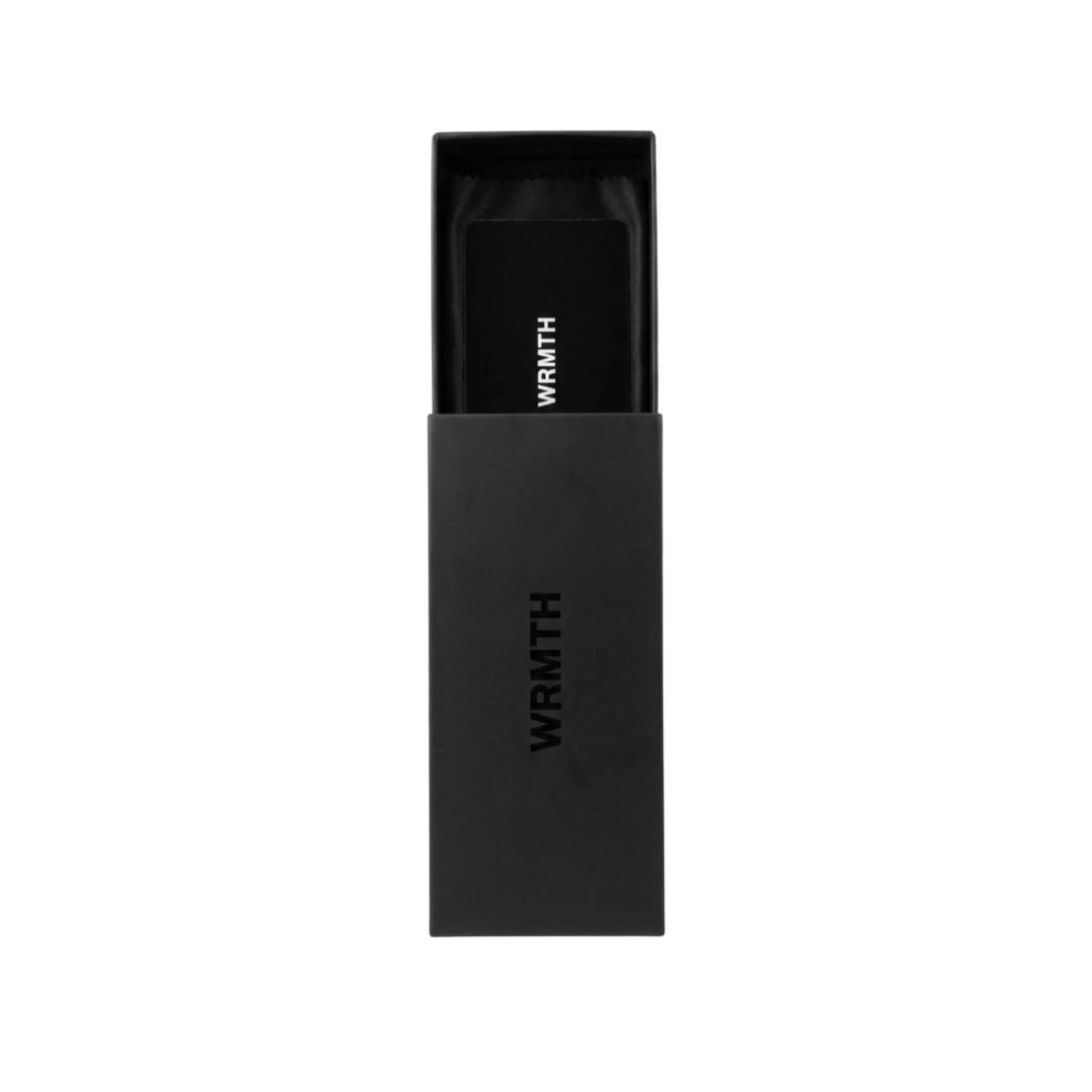 Estuche rígido negro Warmouth con tarjeta de presentación WRMTH, packaging premium incluido con las gafas Dustin.